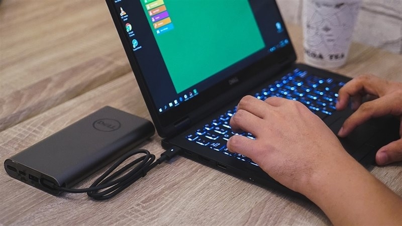 Người dùng laptop đang vừa cắm sạc vừa làm việc bình thường Người dùng laptop đang vừa cắm sạc vừa làm việc bình thường