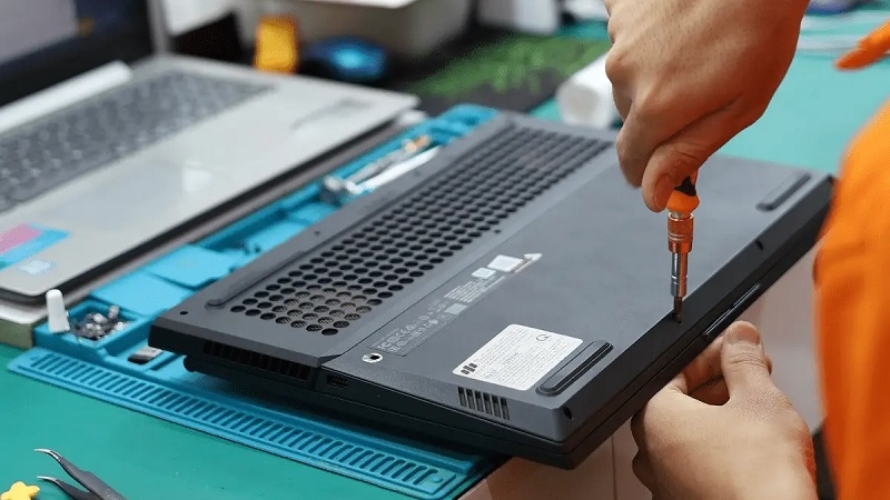 Kỹ thuật viên kiểm tra và tháo pin laptop bị phồng bằng dụng cụ chuyên dụng Kỹ thuật viên kiểm tra và tháo pin laptop bị phồng bằng dụng cụ chuyên dụng