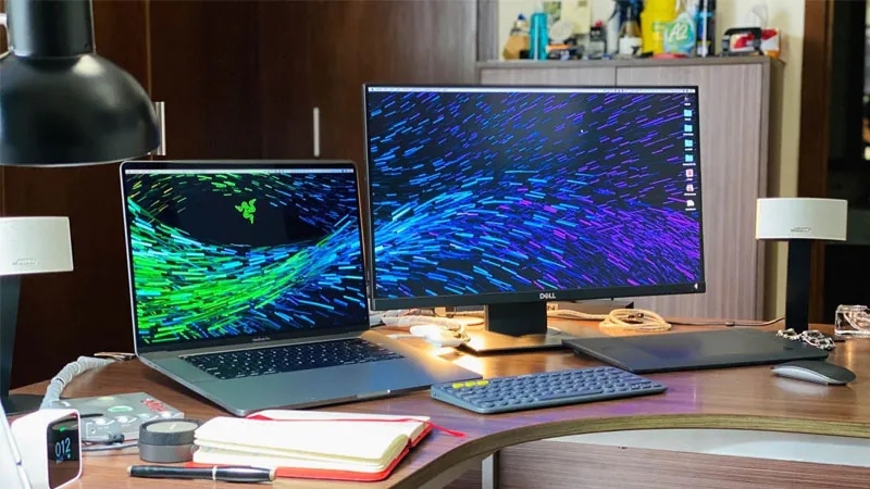 Laptop kết nối với một màn hình ngoài đặt bên cạnh trên bàn làm việc Laptop kết nối với một màn hình ngoài đặt bên cạnh trên bàn làm việc