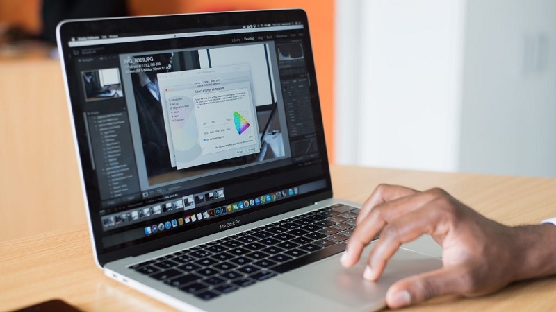 Người dùng lớn tuổi thao tác tắt ứng dụng chạy ngầm trên MacBook